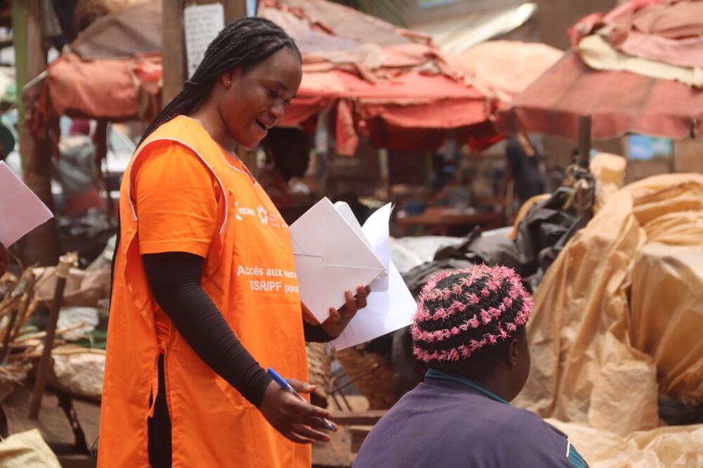 Grace sensitising a woman in the market place. Credit: AfriYAN Cameroon, August 2024